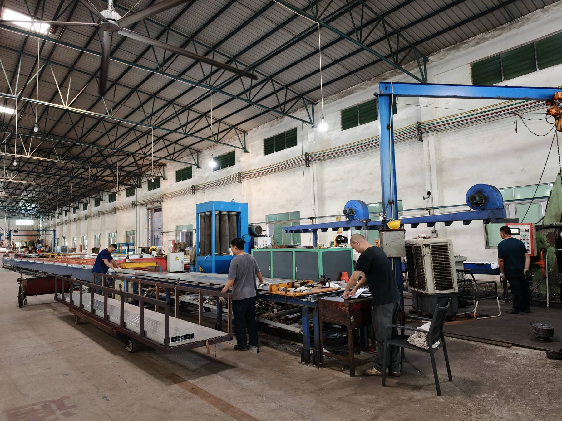 Workers cutting and fabricating aluminum profiles on the line