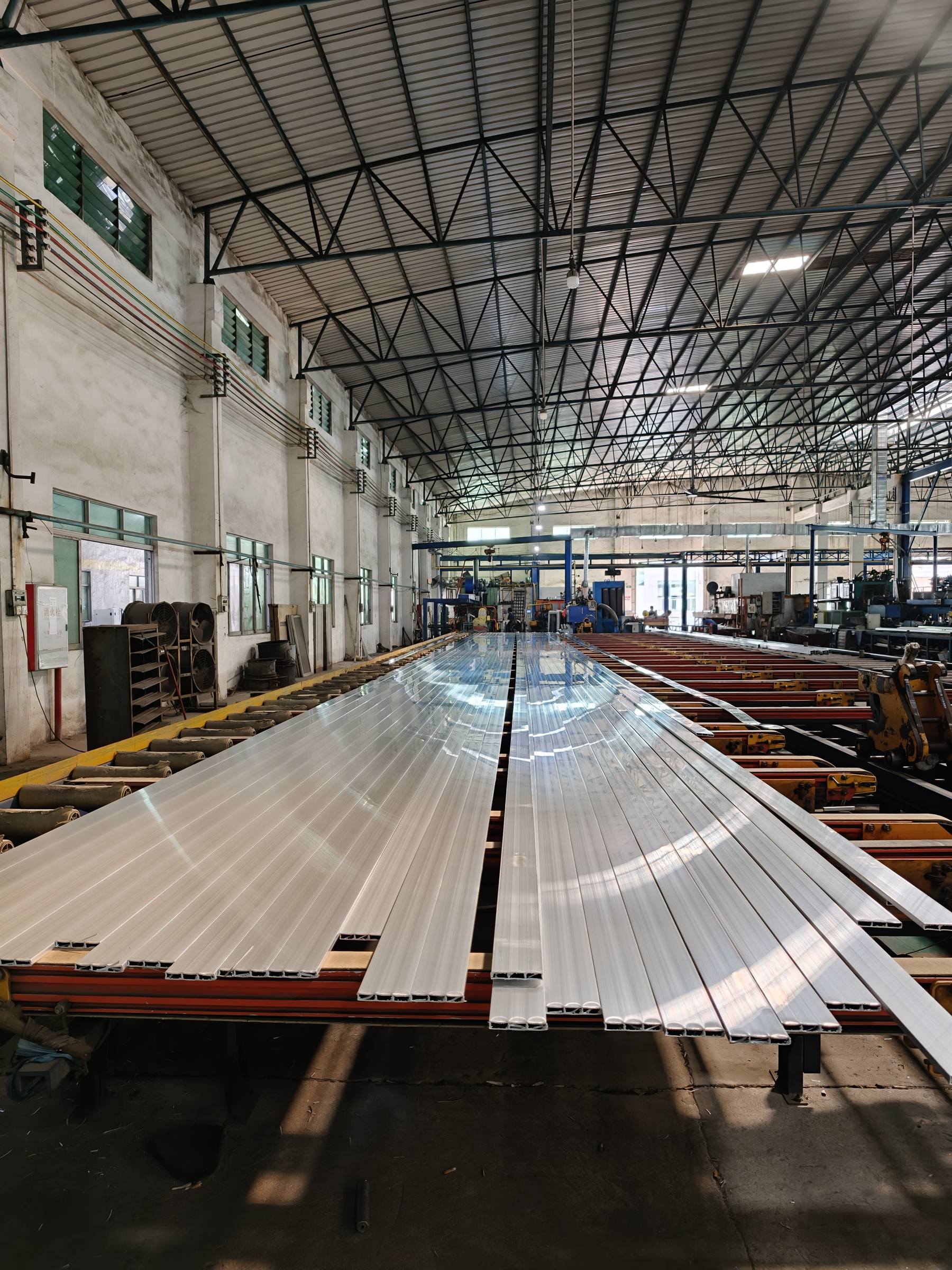 Freshly extruded aluminum furniture profiles on the run-out table